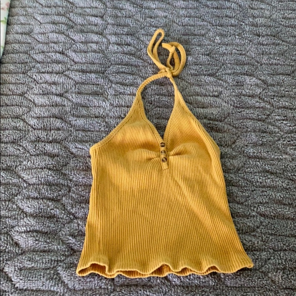 A mustard colored crop top with an open back.